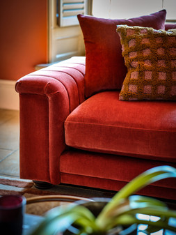 Regency 2 Seater in Regency Fine Textured Chenille Deep Coral All Over with Distressed Walnut Feet and No Studs, £1699. Regency Designer Footstool in Regency Geometric Designer Fabric Copper, £449. Regency Designer Footstool in Regency Geometric Designer Fabric Sky, £449.